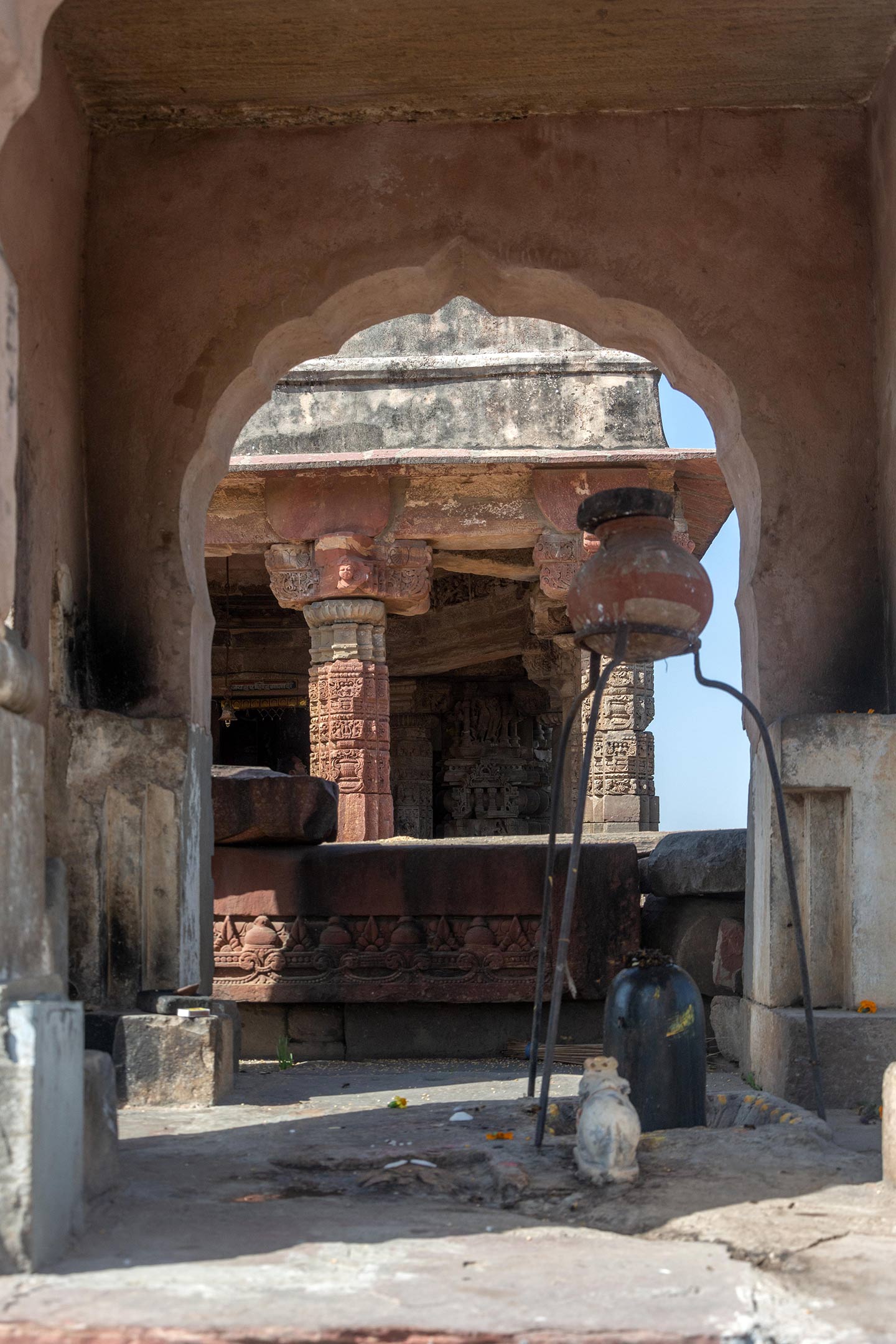 A small shrine, possibly a newer construction, is placed off-centred to the right facing the garbhagriha. The subsidiary shrine has arched openings on the west, (seen here) east and north sides with a rectangular entrance inside an arched niche on the south side. A Shiva lingam made in black stone is installed inside with a Nandi figure next to it. An earthen pot is installed on a tripod which drips water over the Shiva lingam.