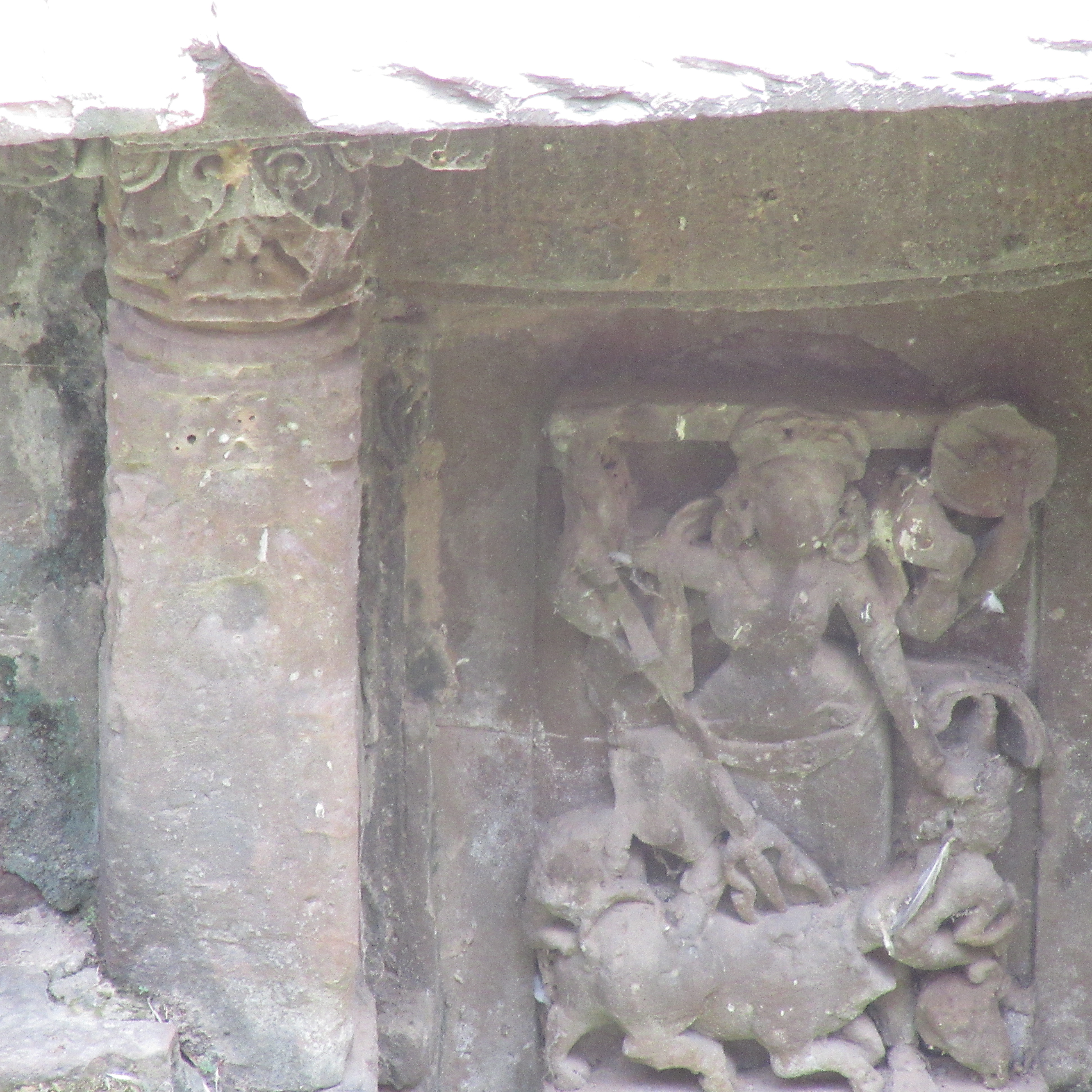 Image 4: Six-armed female deity holding a trident, sword in her right; shield, munda in her left hand, rest is not clear. The leg is pressing on his hump, pressing the demon down. The decapitated head is shown fallen down. The lion chomps at the bull/demon's hip. It is stylistically similar to the multiple Durga Mahishasuramardini images recovered from the Harshatmata temple.